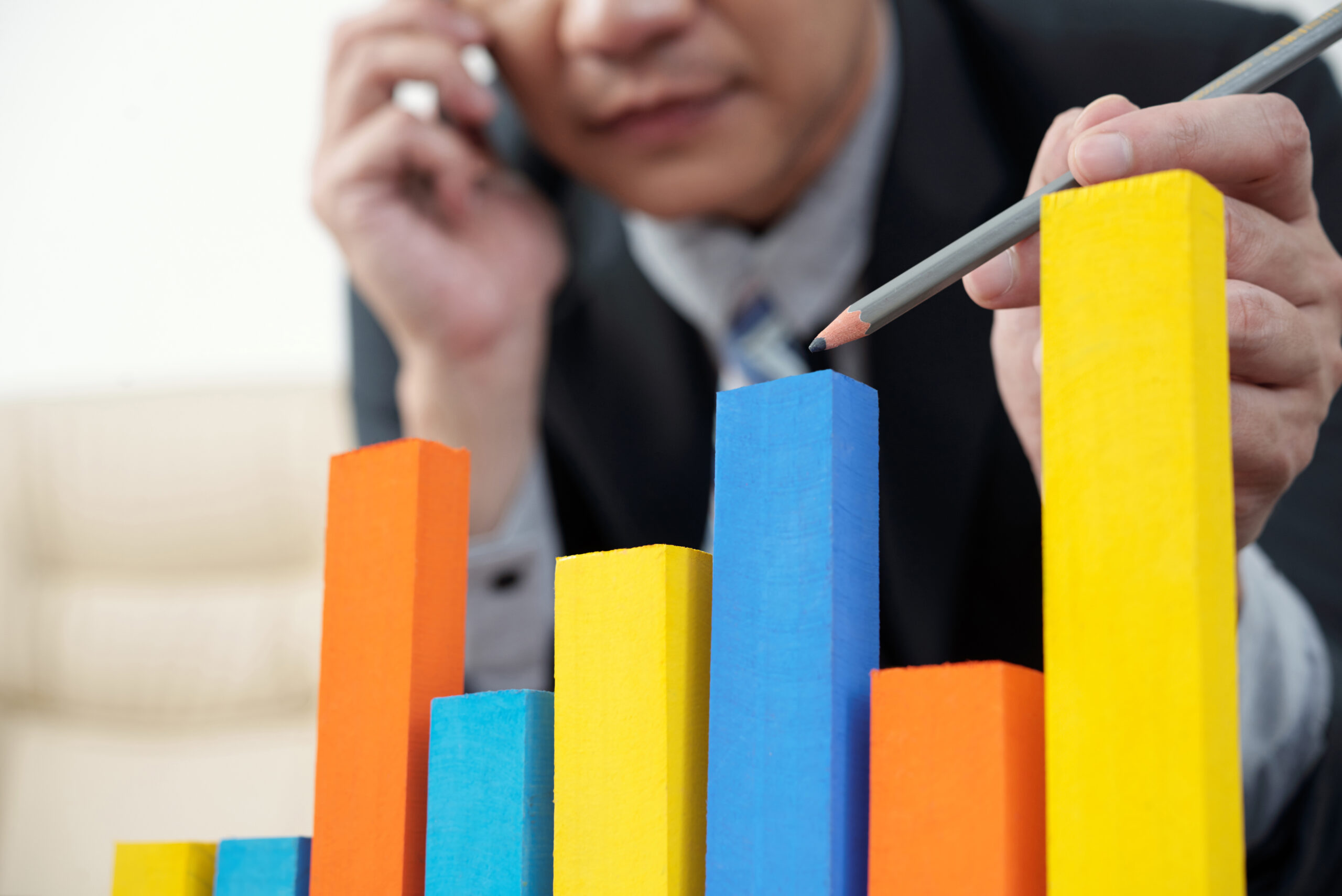 Businessman pointing at colorful blocks imitating financial chart