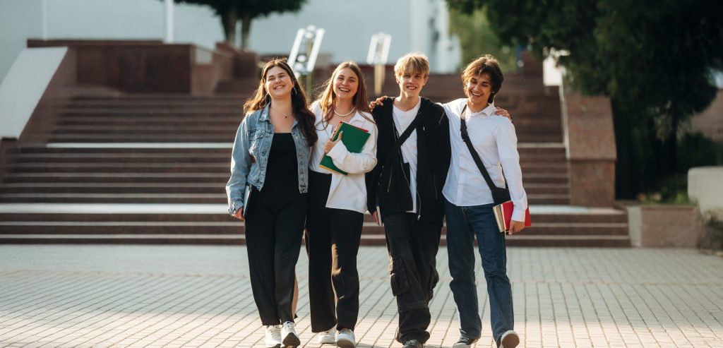 Having a break, walking. Group of students are near university together.
