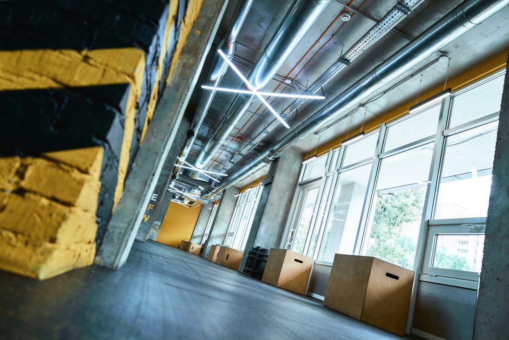 Modern empty gym with crossfit equipment, selective focus on wooden fitness boxes on the floor. Sport concept, health club interior