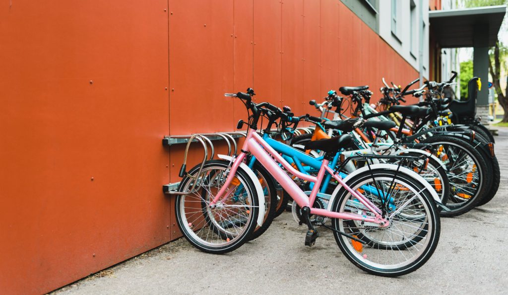 A lot of bicycles on parking near building. Personal transportation